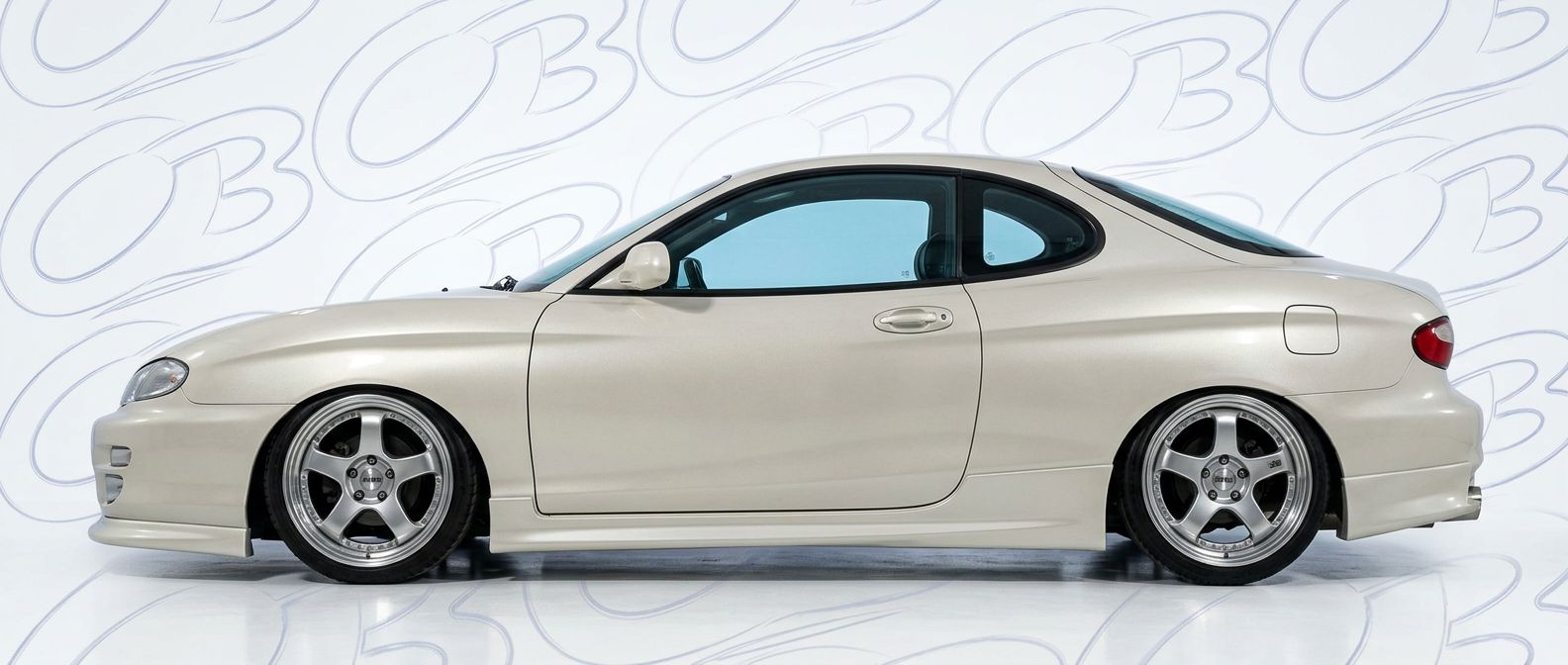 Professional automotive photography of a 1998 Hyundai Tiburon with high-fidelity 1998.